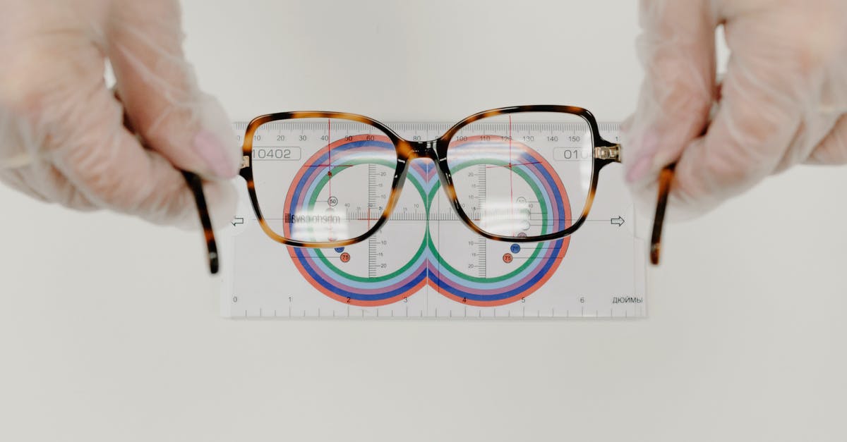 How does Zac's size changes work? - From above of crop anonymous oculist in sterile gloves measuring modern eyewear with optical tool on white background