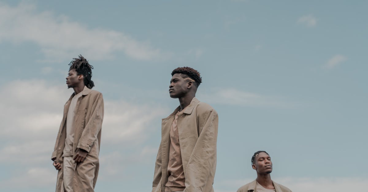 How far away can you be to play MCPE with someone? - Three Men Standing with Cloudy Sky Background