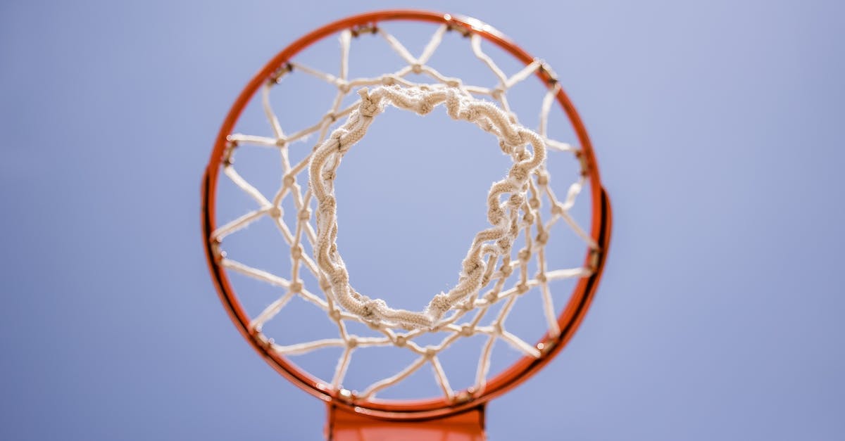 How high can a player go? - From below of metal basketball hoop with net hanging on sports ground against blue sky How high can a player go? - From below of metal basketball hoop with net hanging on sports ground against blue sky
