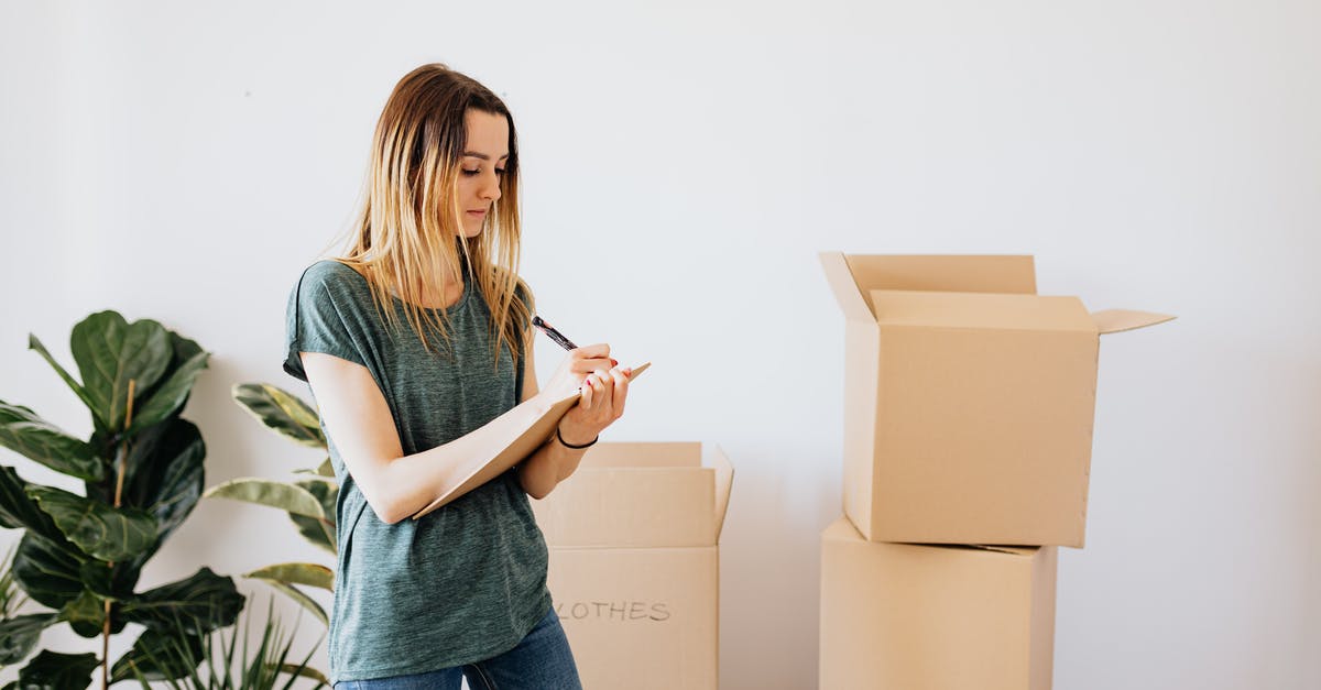 How important is Temperature? - Focused young lady in casual wear taking notes in clipboard while standing near packed carton boxes before moving into new house How important is Temperature? - Focused young lady in casual wear taking notes in clipboard while standing near packed carton boxes before moving into new house