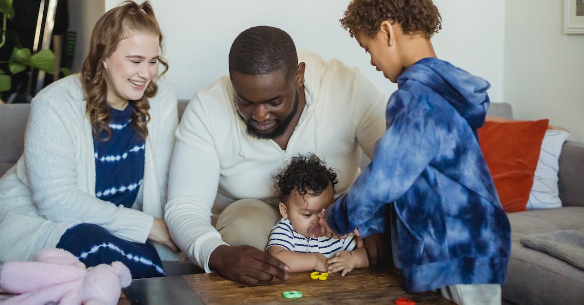 How is the game affected by the species you choose? - Happy multiracial family playing with little cute baby at table with colorful toys at home