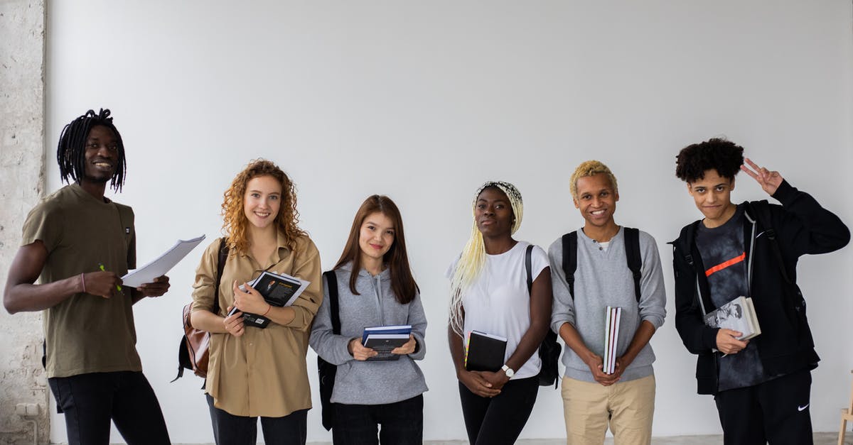 How is victory decided when two civilizations reach Alpha Centauri in the same year? - Group of smiling multiracial classmates standing with books and backpacks and smiling widely at camera