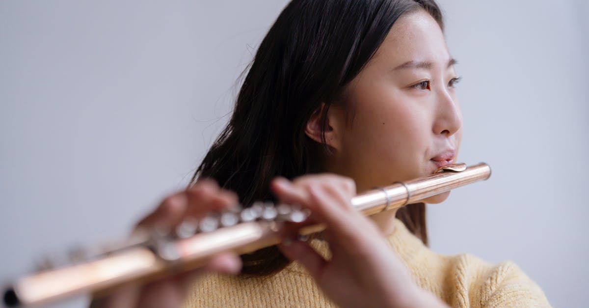 How long do Black Flute repel and White Flute attract effects last? - Young Asian lady in warm sweater playing flute in light room with white wall