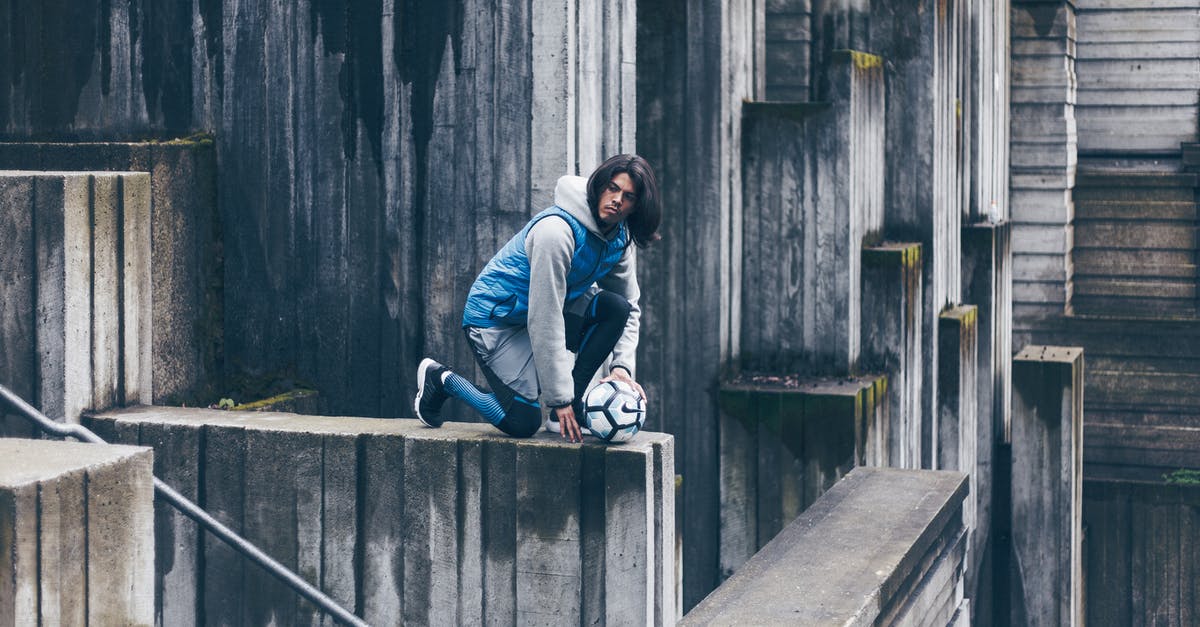 How long do minecrawler mandibles/bloodfly stingers affect player - Side view of concentrated male footballer sitting with ball on stone wall in city and looking away