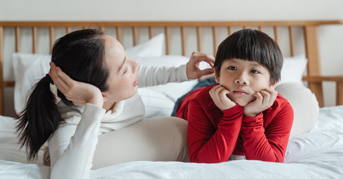 How long do minecrawler mandibles/bloodfly stingers affect player - Tender Asian mother touching hair of cute boy in casual clothes while lying on bed during spare time at home