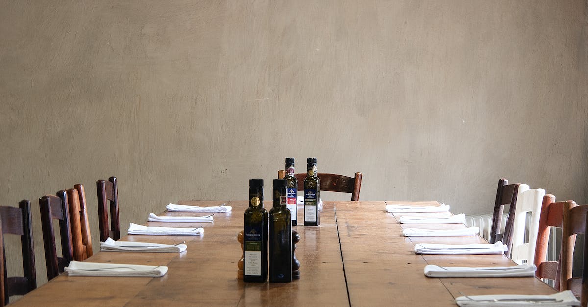 How long do Oil Urns last? - Wooden table with bottles of olive oil and cutlery