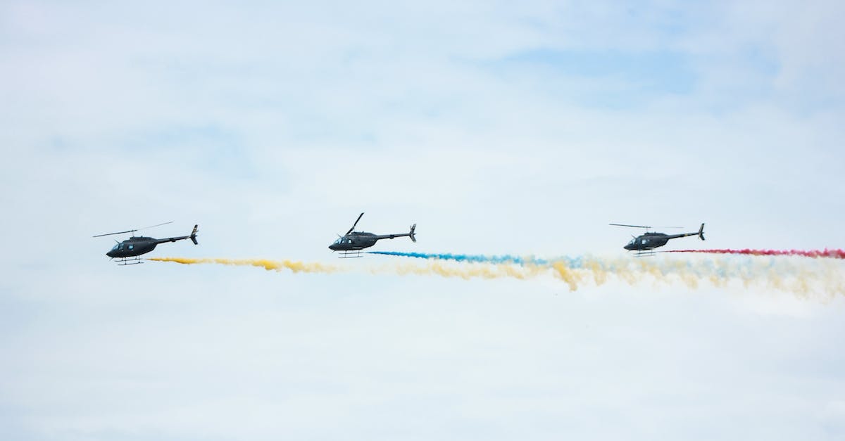 How long does it take for the debuffs from Red's Wings to start? - From below of identical black helicopters with long tails and propellers flying in cloudy sky while leaving colorful wavy traces with smoke effect in daylight