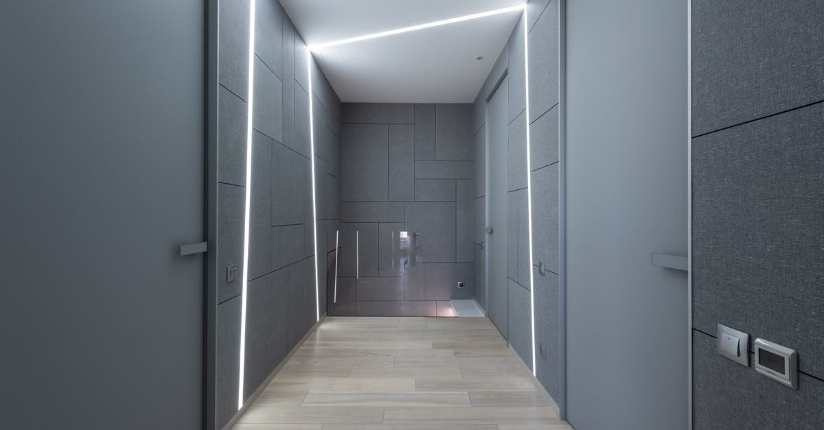 How long does it take to completely lick the door? [duplicate] - Interior of contemporary hallway of creative space with parquet and gray walls with doors and modern bright illumination on ceiling and walls