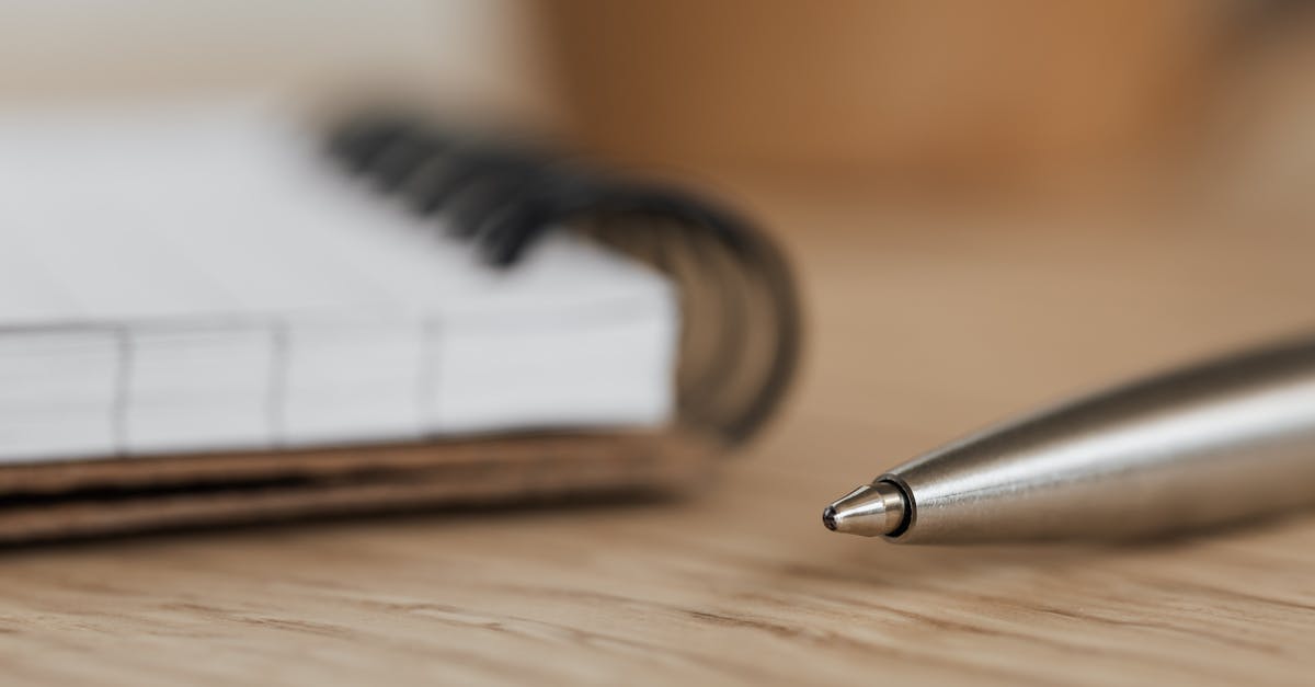 How long does it take to fully draw a bow in Minecraft? - Side view closeup of opened ring bound notebook with blank pages near silver ball point pen placed on wooden table