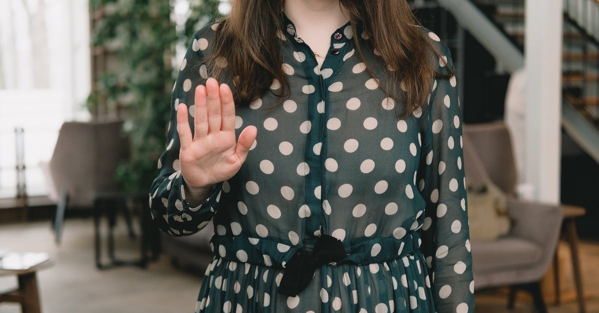 How long until tamed wolves stop attacking in Minecraft? - Crop feminine woman showing stop gesture in modern apartment