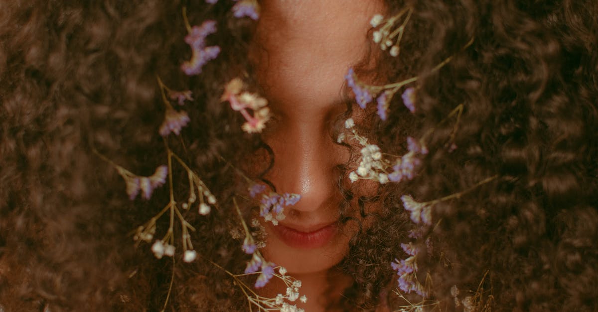 How long until you get the purple shark fin? - Headshot of anonymous content female with small bright flowers with white and purple petals tangled in brown hair covering face