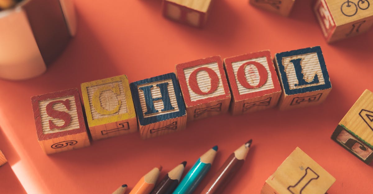 How many Atlas words are there and how do you learn them? - From above of wooden cubes making word school placed near color pencils on red table