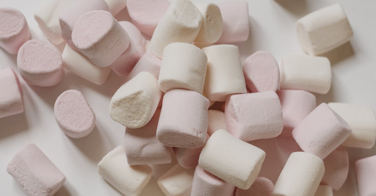 How many candies can a villager eat before moving slower than guards? - Top view arrangement of sweet delicious marshmallows of light color heaped on white surface