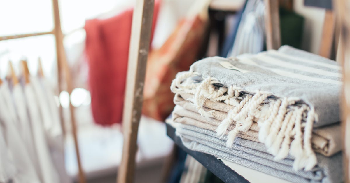 How many daily quests are stored internally? - Unrecognizable female standing near wooden shelf with pile of cotton pads and skincare supplies in bathroom with mirror at home