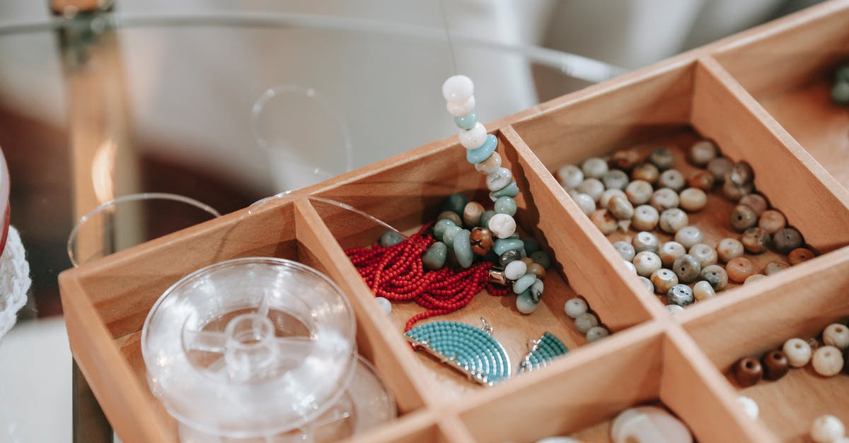 How many games did Romero and Carmack create before Doom? - Wooden container with abundance of colorful beads and elastic cord for making bracelet placed on glass table in light room