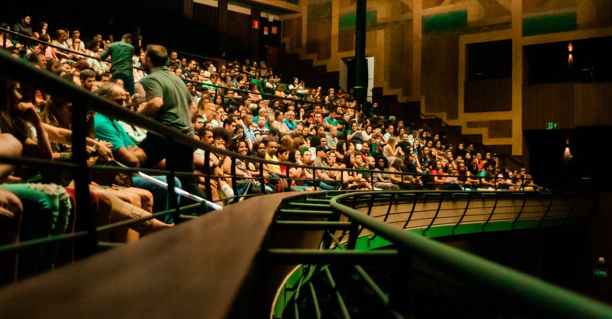 How many hits are necessary to perform each combo named in the game? - Crowd of people sitting on seats in amphitheater with metal railings in modern spacious concert hall while watching live performance
