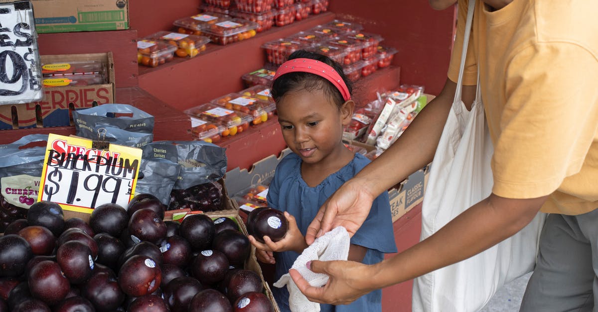 How many kids can I have? - Ethnic girl choosing fruit in market with mother