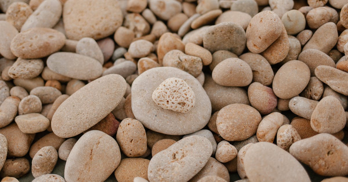 How many mundus stones per zone? - From above of textured background of small stones with blots on surface on shore How many mundus stones per zone? - From above of textured background of small stones with blots on surface on shore