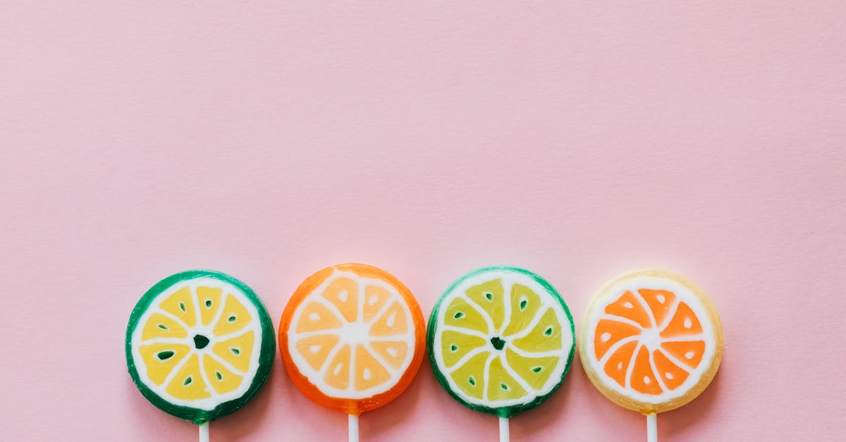 How many of which types of candies do I have? - Top view of round multicolored candies with citrus fruit flavor on thin plastic sticks on pale pink surface How many of which types of candies do I have? - Top view of round multicolored candies with citrus fruit flavor on thin plastic sticks on pale pink surface
