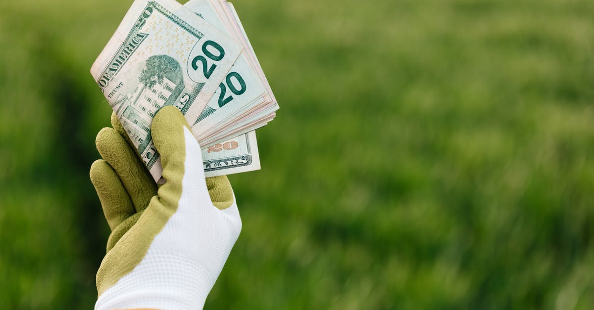 How many Pokemiles does each method earn? - Crop anonymous gardener in gloves showing American paper money with number twenty and photo of building on blurred background with green field in daylight