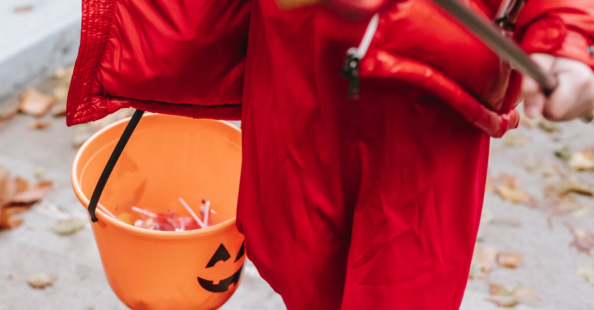 How much candy for walking Pokemon? - Crop anonymous kid in red devil costume for Halloween with pitchfork strolling on street in autumn day How much candy for walking Pokemon? - Crop anonymous kid in red devil costume for Halloween with pitchfork strolling on street in autumn day