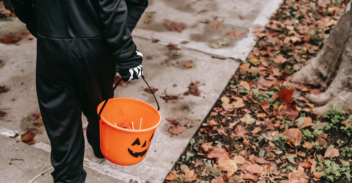 How much candy for walking Pokemon? - Crop faceless kids in black Halloween costumes with orange buckets filled with candies strolling on sidewalk in daytime How much candy for walking Pokemon? - Crop faceless kids in black Halloween costumes with orange buckets filled with candies strolling on sidewalk in daytime