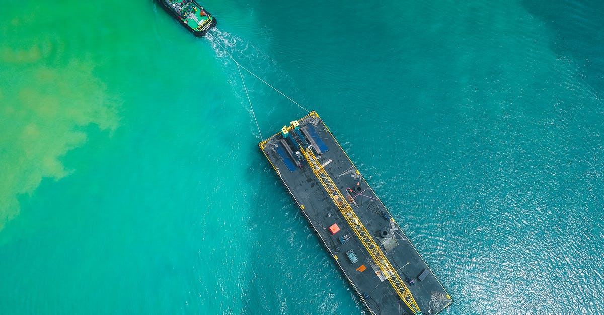 How much cargo does each type of ship typically carry? - Aerial view of modern powerful motorboat floating on azure seawater and transporting big platform with crane How much cargo does each type of ship typically carry? - Aerial view of modern powerful motorboat floating on azure seawater and transporting big platform with crane