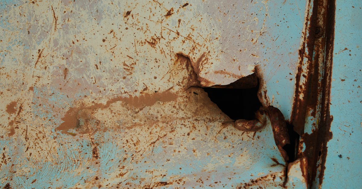 How much damage does it take to destroy metal foundation steps? - Old rusty metal surface of blue color with scratches and hole in abandoned building