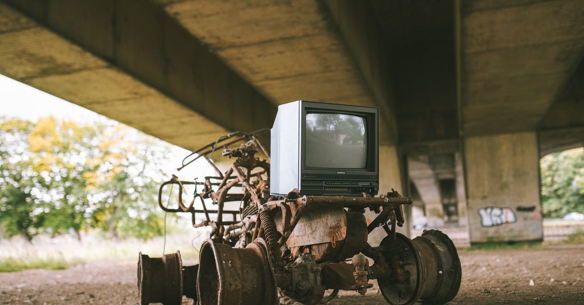 How much damage does it take to destroy metal foundation steps? - Old damaged vehicle with vintage television set on rough pathway under bridge in sunlight