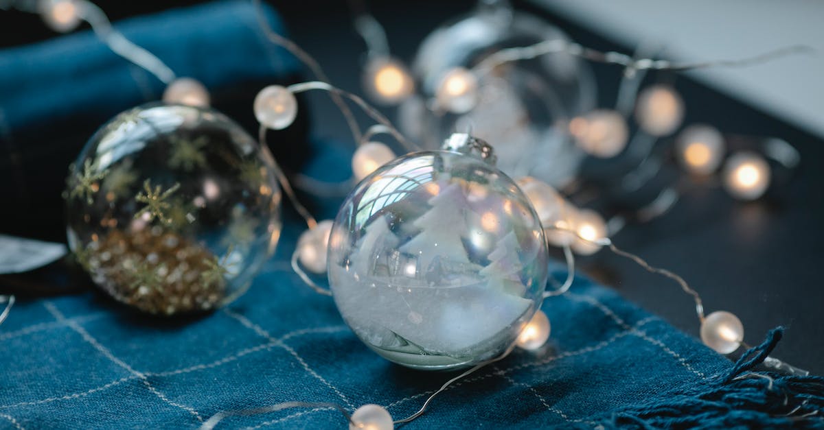 How much damage does Magic Weapon, Greater- and Crystal Magic Weapon add? - Transparent Christmas baubles filled with ornaments on table with blue warm scarf and glowing garland