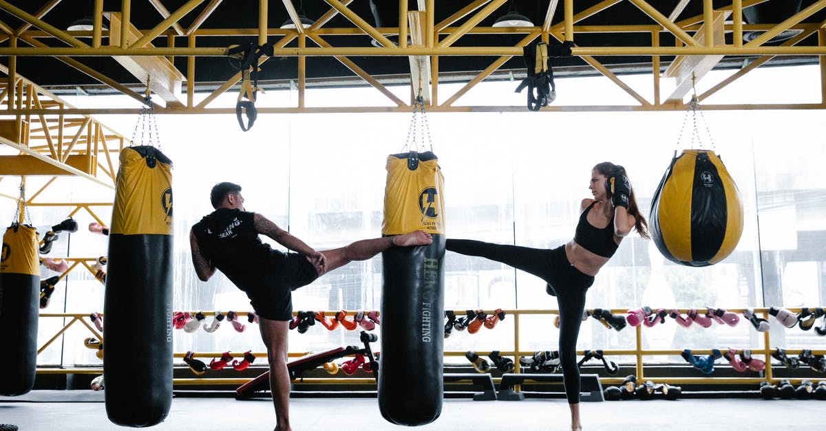 How much fullness does combat drain? - Fit young male and female athletes training on punching bag in gym How much fullness does combat drain? - Fit young male and female athletes training on punching bag in gym