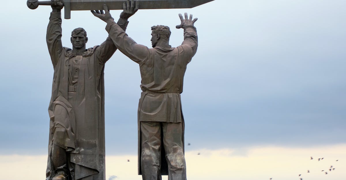 How much is killing heroes worth? - Man Holding a Black Metal Bar Statue