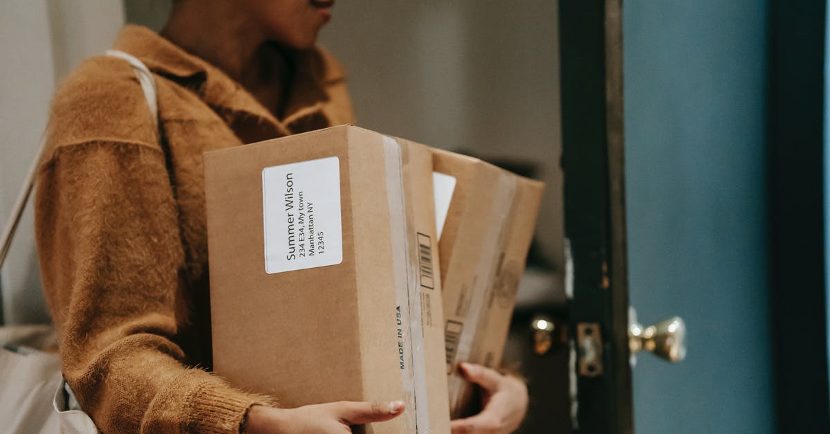 How much Mail is delivered per Prisoner? - Crop ethnic female walking into open door of apartment with carton boxes with goods from delivery