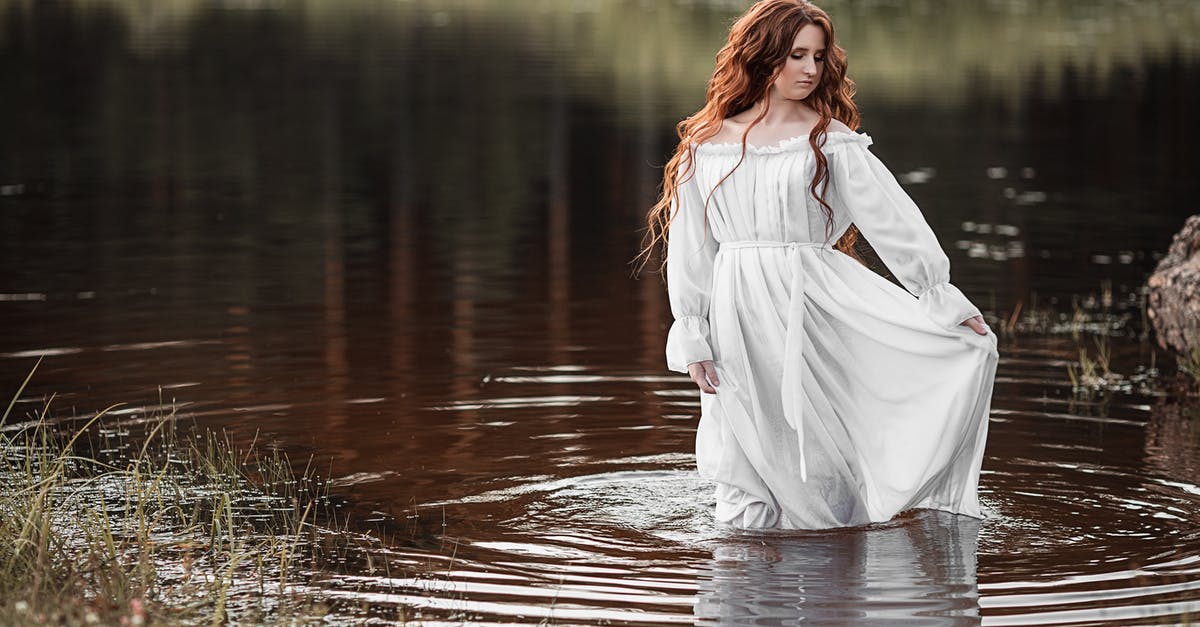 How should I deal with a water nymph in Nethack? - Gorgeous female with long ginger hair and in white elegant dress standing in water and looking down in daylight