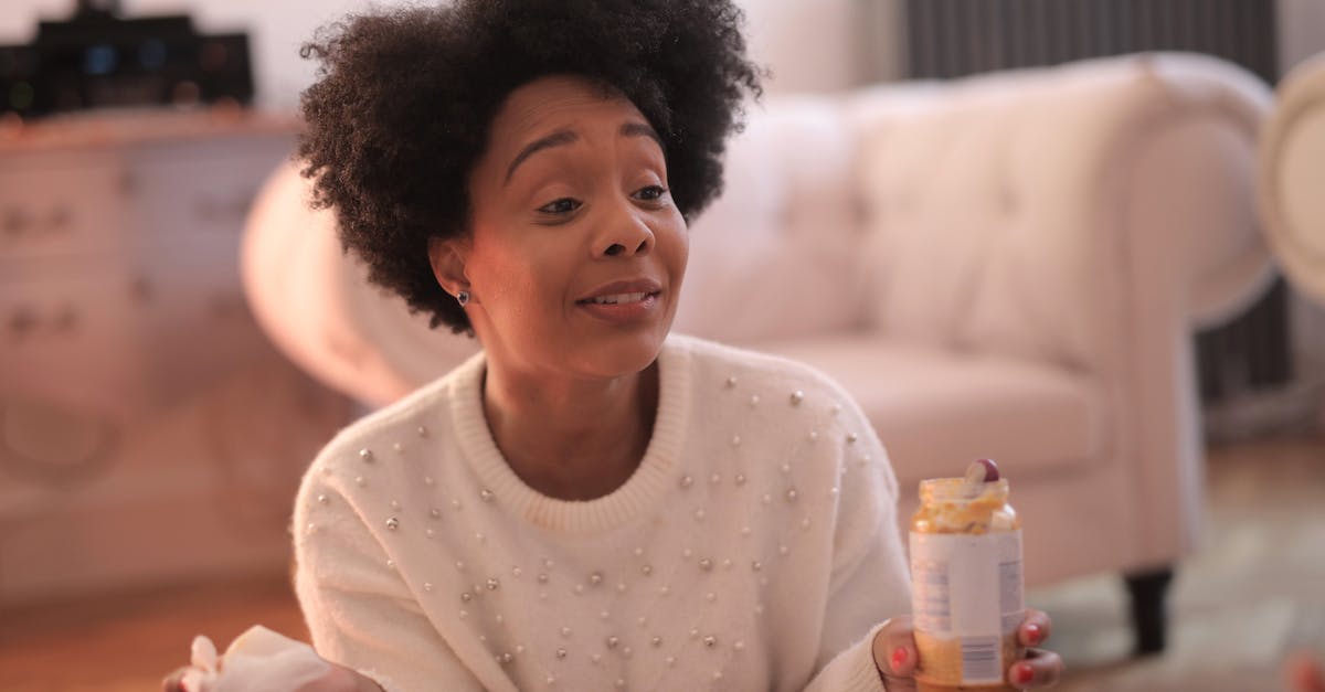 How should I feed my Kinsect for each gameplay style? - Cheerful African American female in warm casual sweater sitting on floor with jar of baby food in cozy living room and looking away How should I feed my Kinsect for each gameplay style? - Cheerful African American female in warm casual sweater sitting on floor with jar of baby food in cozy living room and looking away