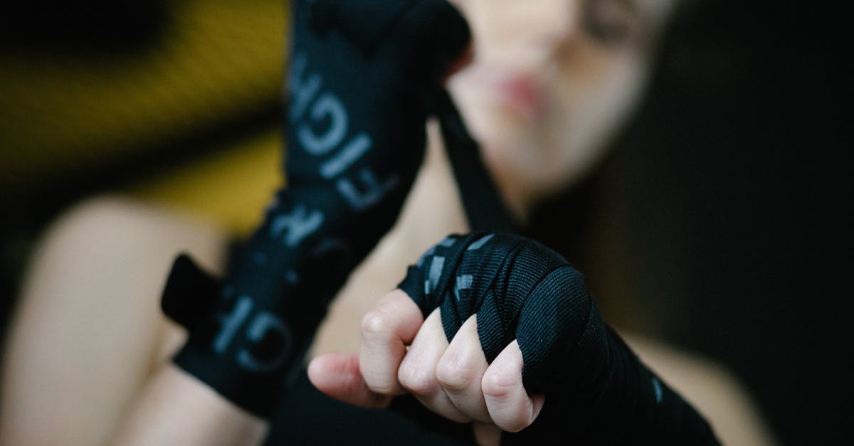 How should I prepare for gym fights? - Soft focus of crop woman bandaging hands and wrists with boxing wraps on blurred background