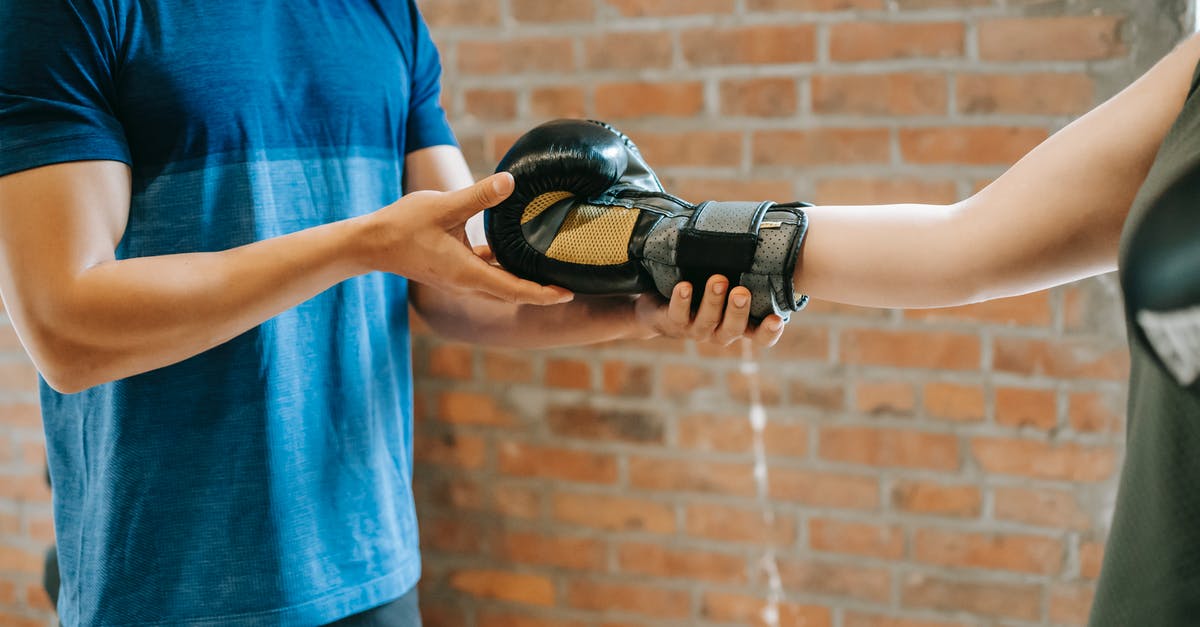 How should I prepare for gym fights? - Personal trainer helping woman putting on gloves How should I prepare for gym fights? - Personal trainer helping woman putting on gloves