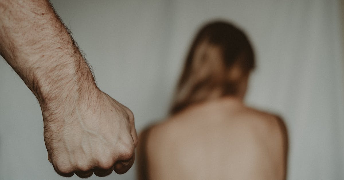 How should I punish my revolting vassals? - Aggressive abusive anonymous man clenching fist while insulting unrecognizable vulnerable female sitting on blurred background in light room during violence How should I punish my revolting vassals? - Aggressive abusive anonymous man clenching fist while insulting unrecognizable vulnerable female sitting on blurred background in light room during violence