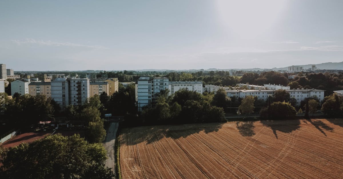 How tall should I build my minecraft mob farm? [duplicate] - Drone view of small town with plantation and lush greenery under foggy sky