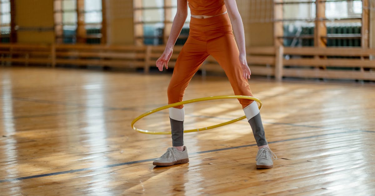 How to access the MasterLeague training menu? - Woman in Orange Long Sleeve Shirt and Brown Pants Wearing White Nike Sneakers Jumping on Brown