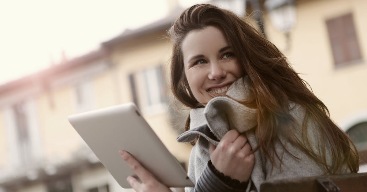 How to activate a PS3 to access downloadable content? - Smiling woman messaging on tablet in city