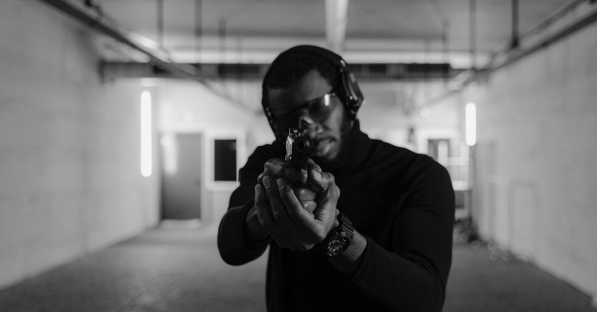 How to aim at long range with 2x scopes? - A Man in Black Long Sleeves Shirt Aiming a Pistol