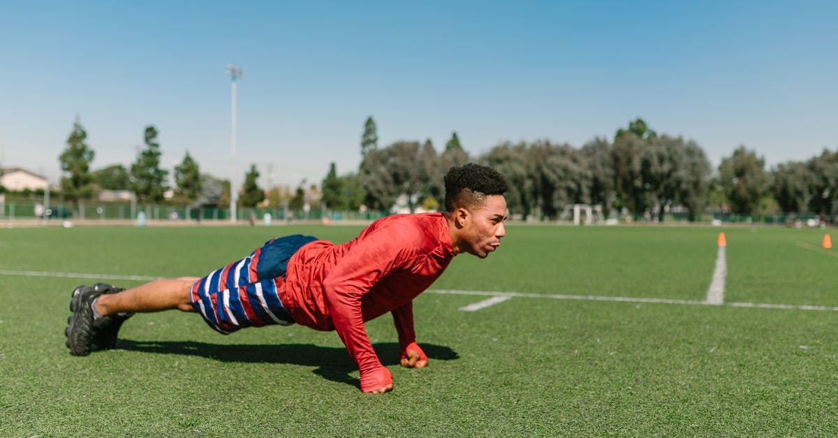 How to avoid leveling up while training - Man in Red Long Sleeve Shirt and Blue and White Striped Pants Kneeling on Green Grass