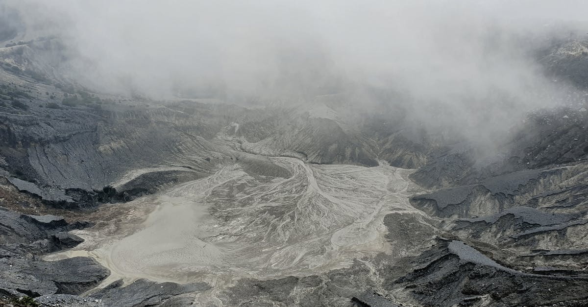 How to avoid the loot from the dragon falling into the lava - From above severe view of rough volcanic crater with hot foamy water and rocky peaks covered with dense mysterious haze How to avoid the loot from the dragon falling into the lava - From above severe view of rough volcanic crater with hot foamy water and rocky peaks covered with dense mysterious haze