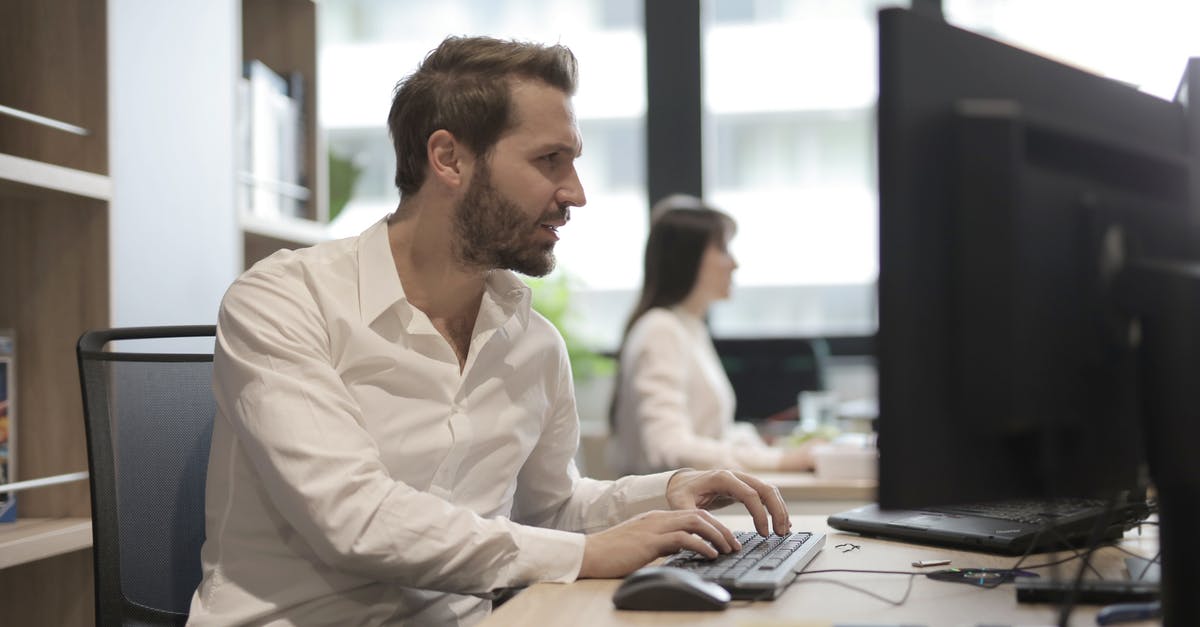 How to breed specialist pops instead of worker pops and how to manage overpopulation on my capital? - Side view of concentrated young bearded employee in white shirt sitting at wooden desk and typing on keyboard while working on computer in light modern office