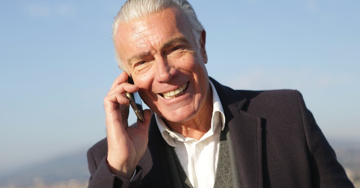 How to chat to all - Delighted male entrepreneur wearing classy jacket standing in city and making phone call while smiling and looking at camera How to chat to all - Delighted male entrepreneur wearing classy jacket standing in city and making phone call while smiling and looking at camera