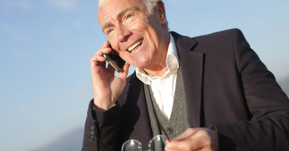 How to chat to all - Mature businessman having conversation on smartphone in city How to chat to all - Mature businessman having conversation on smartphone in city
