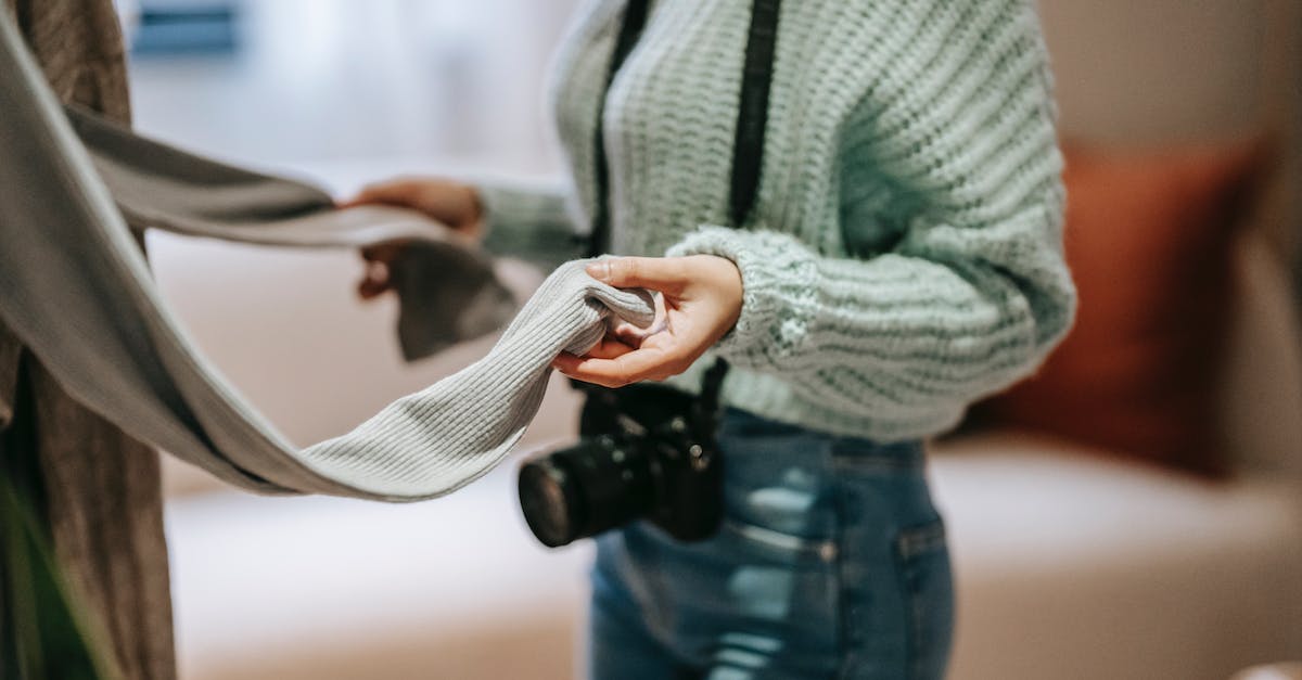 How to choose save device for downloads on Xbox Live - Crop photographer with photo camera touching apparel at home