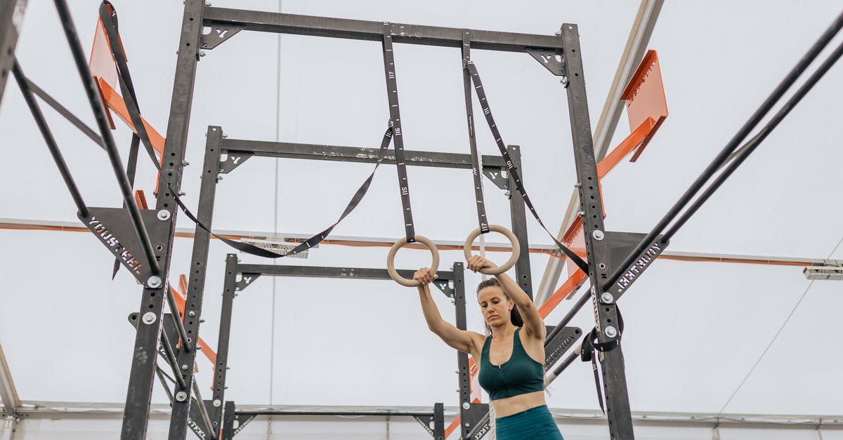 How to climb up when hanging in the Female Ward chapter? - Woman in Blue Tank Top and Blue Denim Jeans Hanging on Black Metal Bar
