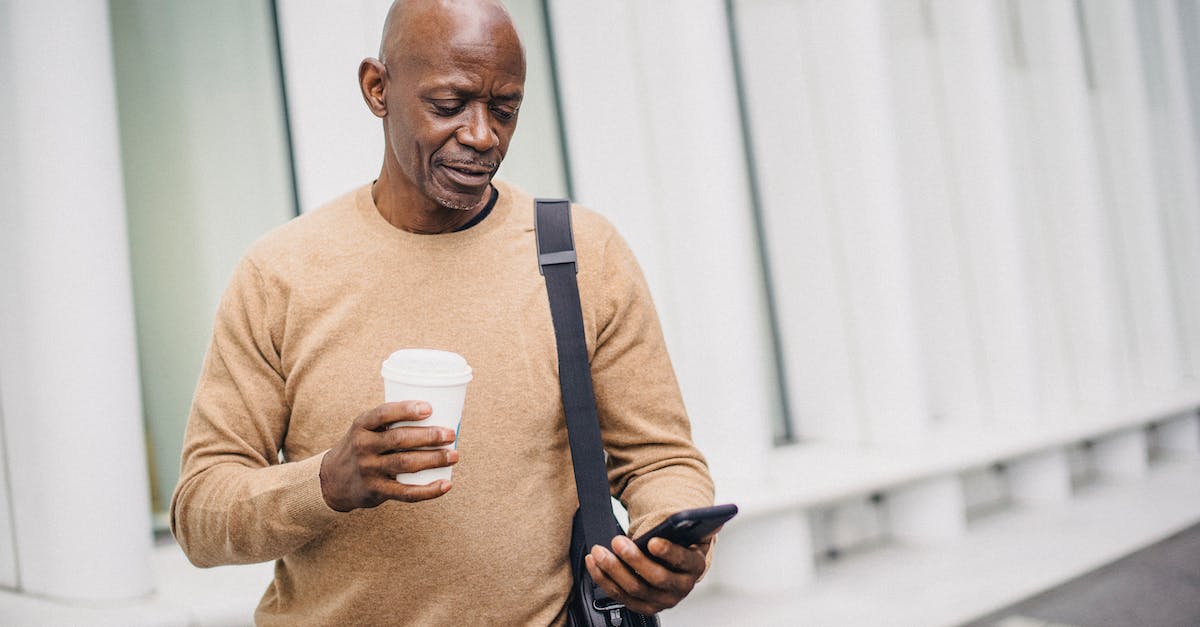 How to configure Media center (Wi-Fi) on the PS4? - Content ethnic businessman texting on phone in city